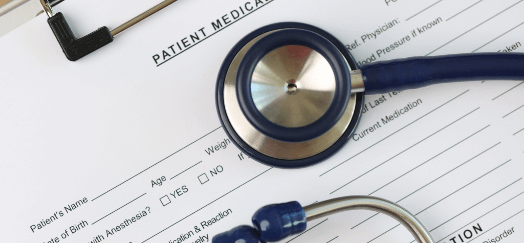 A stethoscope sits on a patient's medical records