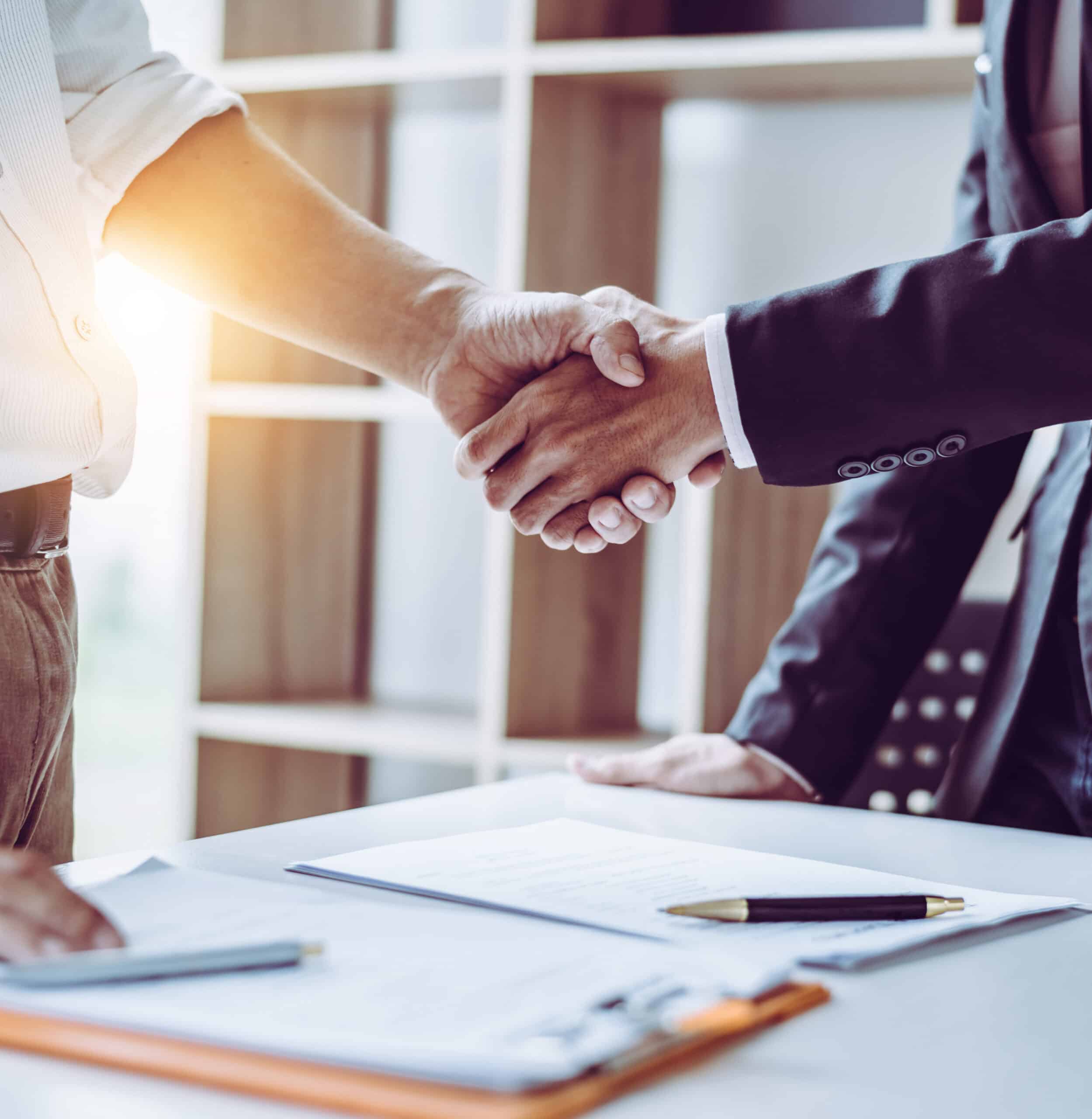 Middle age partner lawyers attorneys shaking hands after discussing a contract agreement done, Asian people.