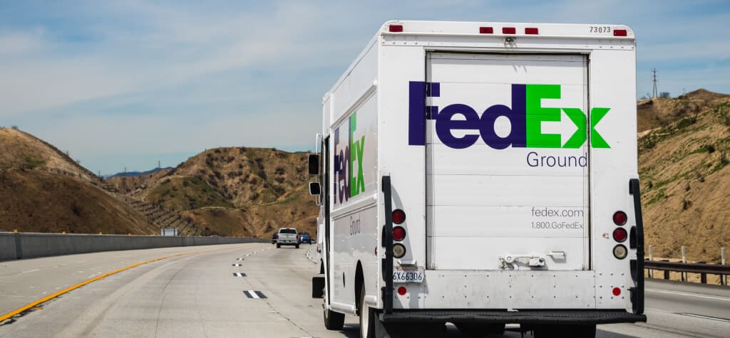 The back of a FedEx truck as it drive down a highway