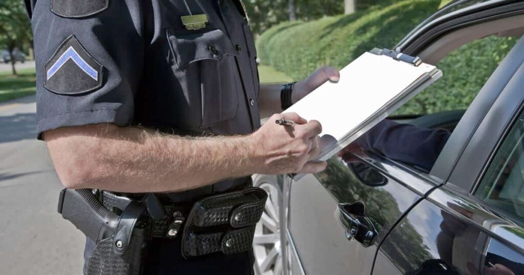 A close-up of a police officer writing a ticket