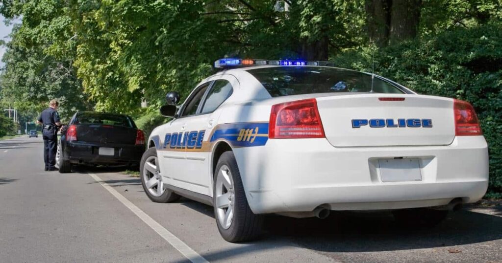 A police car is parked behind a pulled over car 