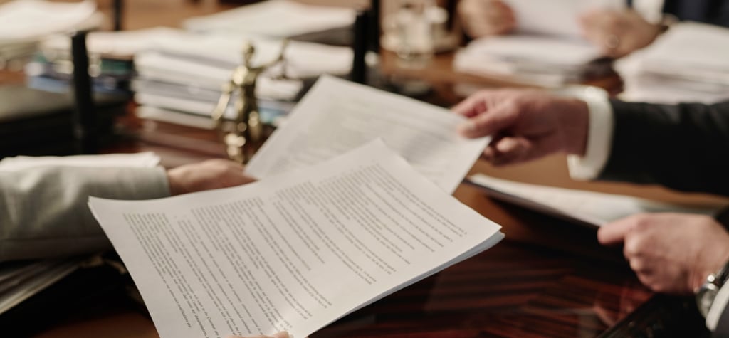 Lawyers exchanging documents at a meeting table