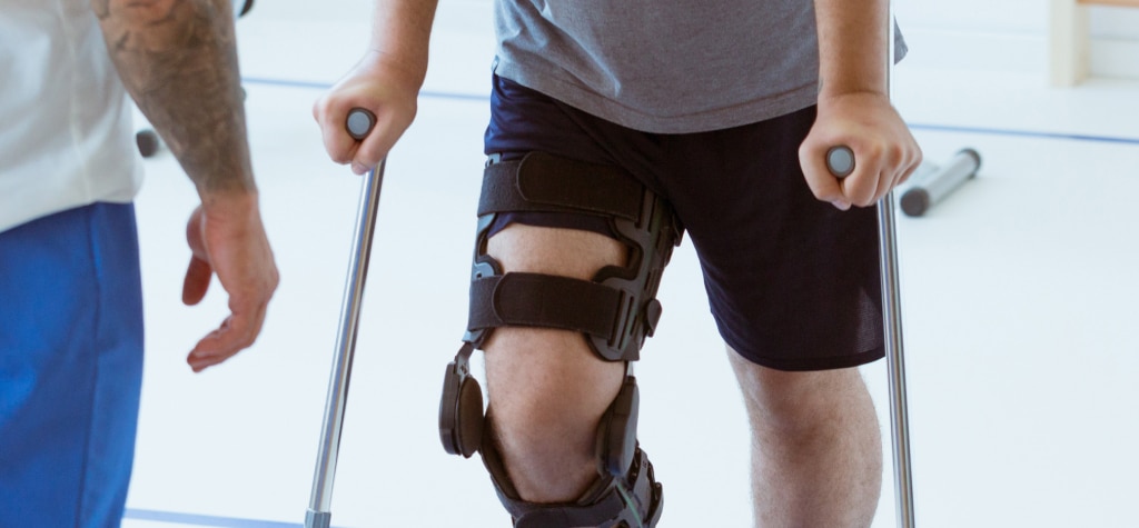 Person with an injured knee using crutches for support