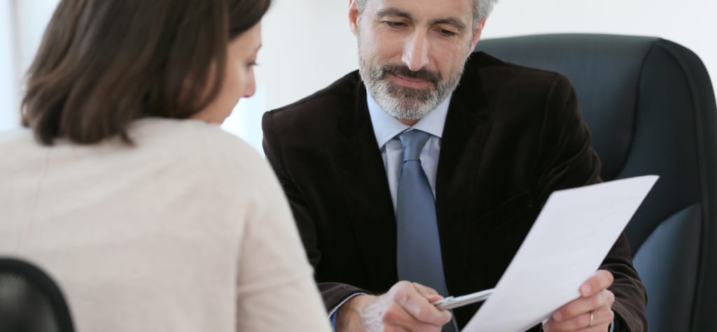 Lawyer discussing documents with a woman in an office setting